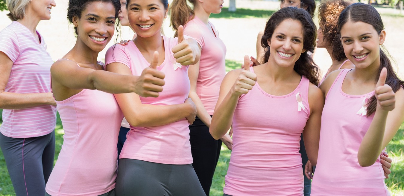 Portrait of happy female breast cancer participants gesturing th